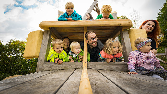 Kinder und Erwachsene in Spielplatzauto