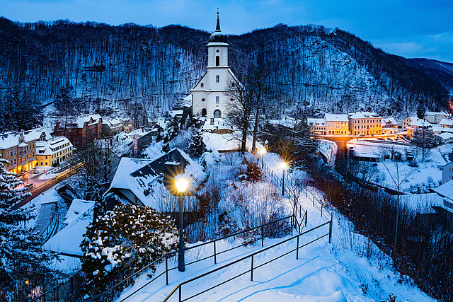 Blick auf ein beschneites Dorf mit Kirche.