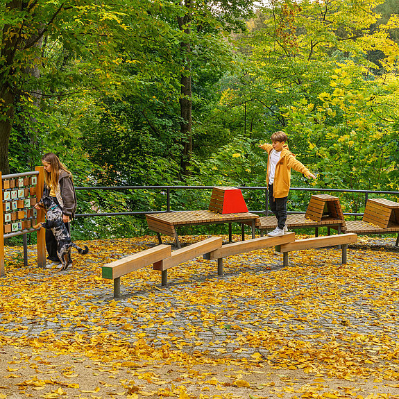 Kind läuft über Holzbalken